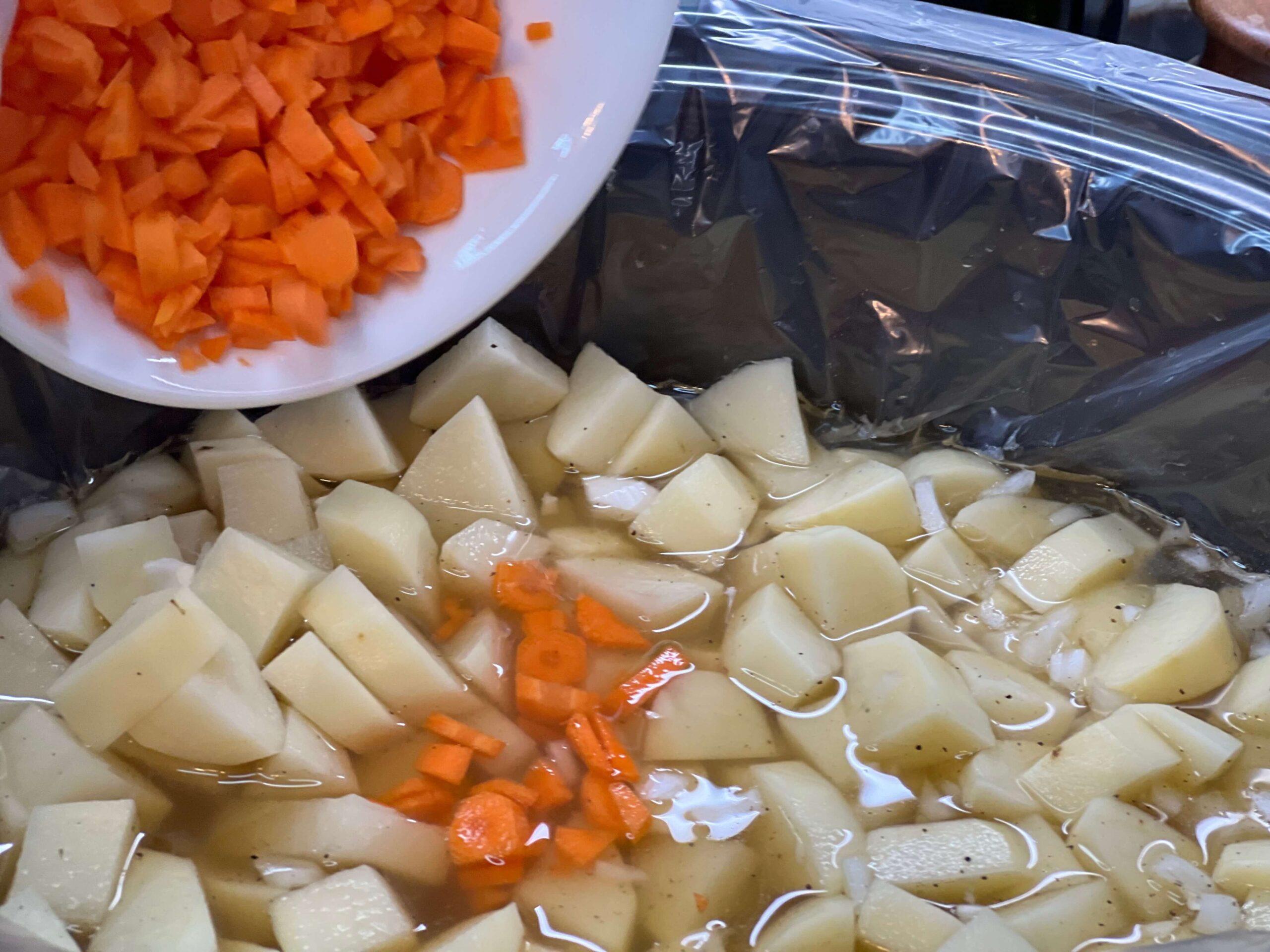 Add diced potatoes and carrots to the slow cooker.