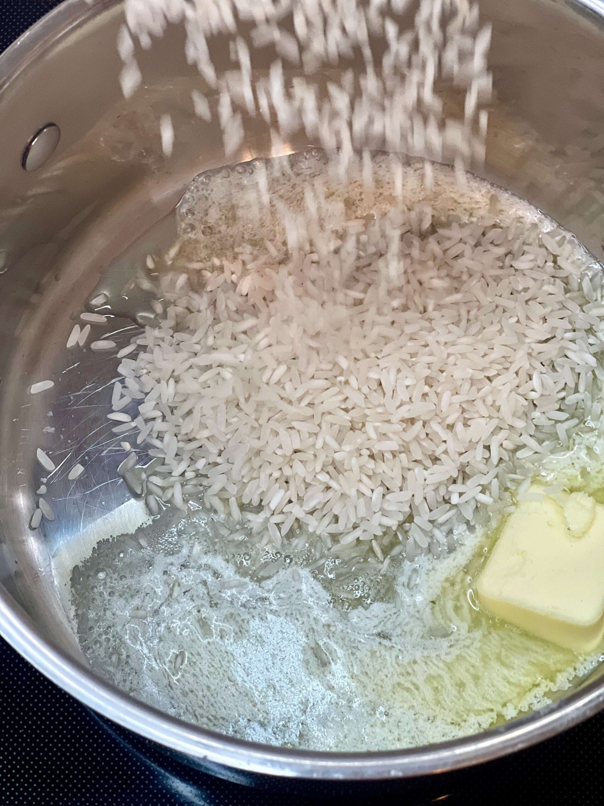 Lightly toast the rice in the melted butter. Also, add the chopped onion at this time.